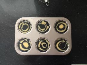 然后一勺原色面糊、一勺竹炭面糊交替倒入模具中，九分满。