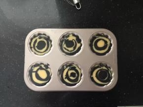 然后一勺原色面糊、一勺竹炭面糊交替倒入模具中，九分满。
