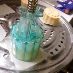 把模具放在油纸上，往下压5秒钟，推出月饼胚即可。