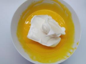 取1/3的蛋白霜加入到蛋黄糊中，用橡皮刮刀用翻拌的手法拌匀。