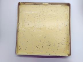 将面糊从15cm的高处倒入烤盘中，用刮刀稍微抹平，再震两下。