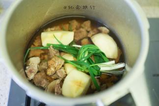 3、	牛腩处理好倒入高压锅，加入切块取芯的一个苹果、葱姜、酱油 料酒 开水没过牛腩