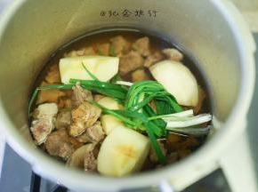 3、	牛腩处理好倒入高压锅，加入切块取芯的一个苹果、葱姜、酱油 料酒 开水没过牛腩