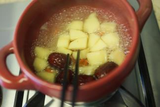 6、	取砂锅一个加入开水、一个苹果去皮切块煮五分钟筷子可以轻轻夹断