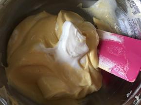 取1/4的蛋白霜加入到混合了牛奶的那一份蛋黄糊里搅拌均匀