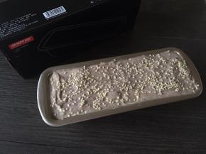 倒入21cm长方形蛋糕模具，抹平表面后撒上白芝麻