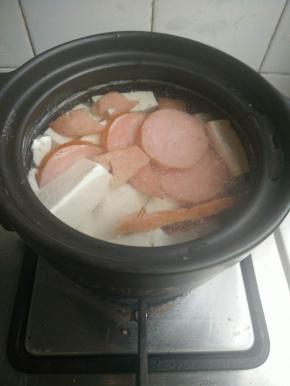 砂锅里放清水或者老汤。放入豆腐，火腿