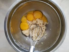 8.将四个鸡蛋进行分蛋，蛋白放另一个干净的打蛋盆中，蛋黄放入面粉中。