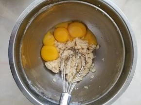 8.将四个鸡蛋进行分蛋，蛋白放另一个干净的打蛋盆中，蛋黄放入面粉中。