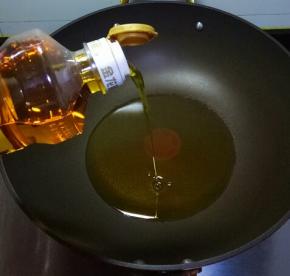 炒锅中倒入金龙鱼菜籽油
