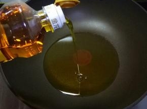 炒锅中倒入金龙鱼菜籽油