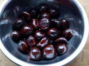 把切好花刀的栗子放入一个小盆里，加入适量油，搅拌均匀使每一粒栗子都沾上油