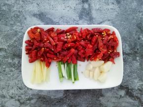 干红辣椒切段，姜切丝，葱切段，蒜瓣去皮