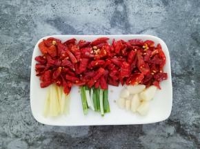 干红辣椒切段，姜切丝，葱切段，蒜瓣去皮