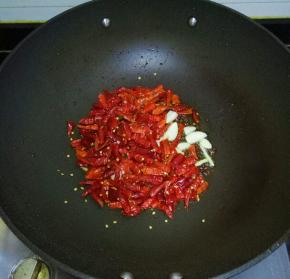 放入干红辣椒，蒜瓣，翻炒至呛鼻