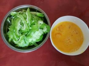 苦瓜去囊切薄片，鸡蛋打到碗里用筷子打散