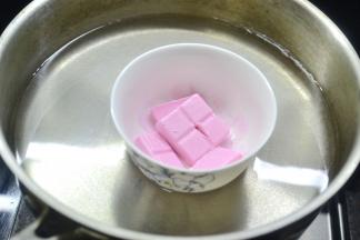 将草莓巧克力、橙香巧克力分别装入小碗隔热水融化