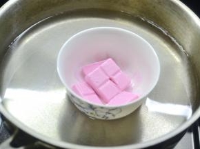将草莓巧克力、橙香巧克力分别装入小碗隔热水融化