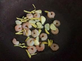 热锅下油，放入蒜片爆香，倒入虾仁