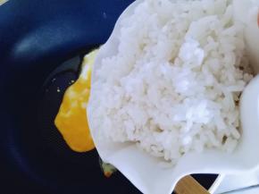将熟米饭倒入锅中。