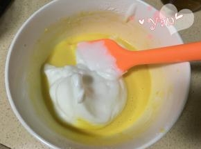 8、舀一大勺蛋白到蛋黄糊里；