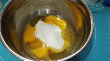 将全蛋液隔水加热至40度左右，加入151g细砂糖。