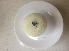 盘中装入米饭、少许芝麻点缀