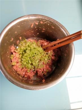 把切碎的花梗倒入腌好的肉末中搅拌均匀