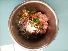 将料酒、酱油、蚝油、盐、姜末、葱花、生粉加入肉中顺一个方向搅打上劲腌制备用。