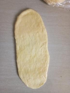 取松施好的面团用擀面仗擀成椭圆形。