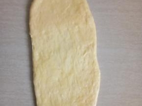 取松施好的面团用擀面仗擀成椭圆形。