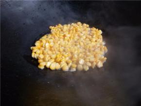 小火，倒入玉米粒。不要立即用铲拨动。等半分钟左右再用铲搅散，稍微炒几下待玉米粒成金黄后关火。