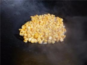 小火，倒入玉米粒。不要立即用铲拨动。等半分钟左右再用铲搅散，稍微炒几下待玉米粒成金黄后关火。