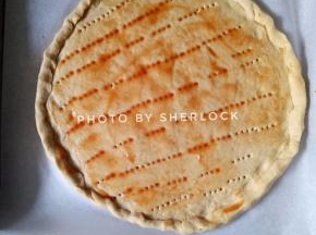 3. 擀成薄薄的圆形，边缘可以卷起一些，用叉子的面饼上插一些小孔，抹上一大勺番茄酱