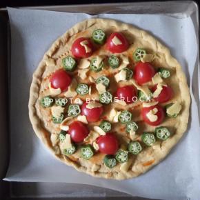 4. 在面饼上铺上圣女果，秋葵，芝士片捏小块随意撒开
最后撒上一些罗勒香料和现磨黑胡椒碎