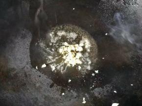 热锅下油，倒入一半蒜蓉爆香