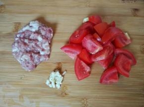 猪肉剁成碎末，番茄切块，蒜剁蓉