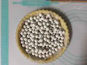 取出冷冻的派皮，垫上锡纸或油纸（压上重石）烤箱预热200度烘烤25分钟左右