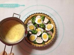 将馅料的食材铺满在烤好的派皮上，倒入馅料液至9分满
