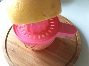 西柚用手动榨汁器挤出汁水