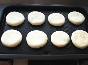 电烤盘预热5分钟以上，刷一层薄油，放上按扁的馅饼。