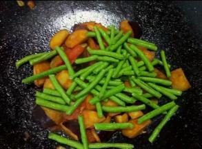 接着倒入豆角翻炒