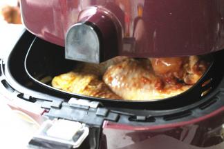 腌制好的鸡小腿，送入炸锅内，我还在底部铺了些胡萝卜块，会超级好吃的。