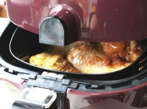 腌制好的鸡小腿，送入炸锅内，我还在底部铺了些胡萝卜块，会超级好吃的。