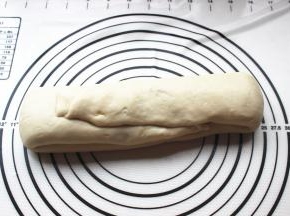 抹好麻酱的面片卷起来，两头如图折上去，按一下按扁，然后再放置醒发15分钟。