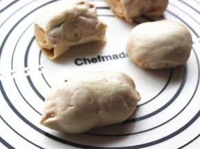 两头揪起来捏紧，包住麻酱，收口团一团压在下面，略微按扁一些。