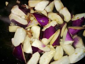 放入蒜头，接着倒入茄子翻炒