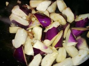 放入蒜头，接着倒入茄子翻炒