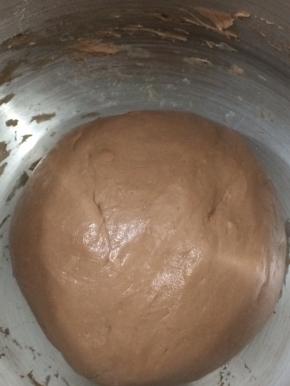 然后先用慢速1档把所有材料搅成团，再转2档高速搅拌面团到成团，揉好后的面团，拿出来揉成圆，放在桶里，用保鲜膜盖住，进行静置一小时