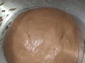 然后先用慢速1档把所有材料搅成团，再转2档高速搅拌面团到成团，揉好后的面团，拿出来揉成圆，放在桶里，用保鲜膜盖住，进行静置一小时
